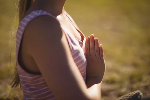 Mid section of woman practicing yoga during obstacle course in boot camp