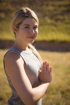 Portrait of beautiful woman praising yoga during obstacle course in boot camp