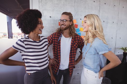 Cheerful business people talking in creative office