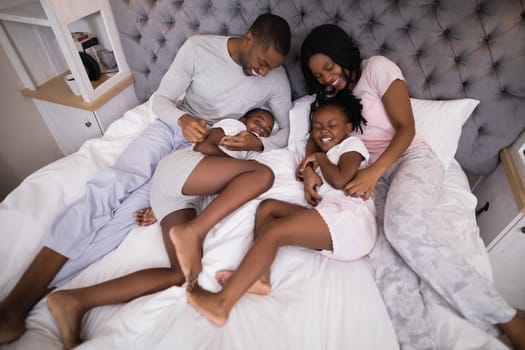 High angle view of family enjoying together on bed at home