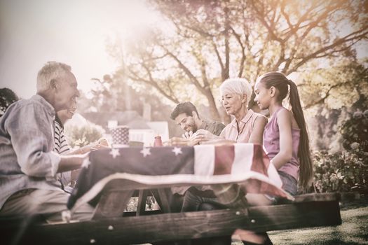 Happy family having a picnic on an american tableclothe