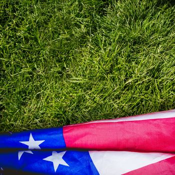 Creased US flag against grass background