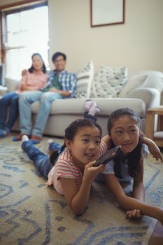 Family watching television together in living room at home