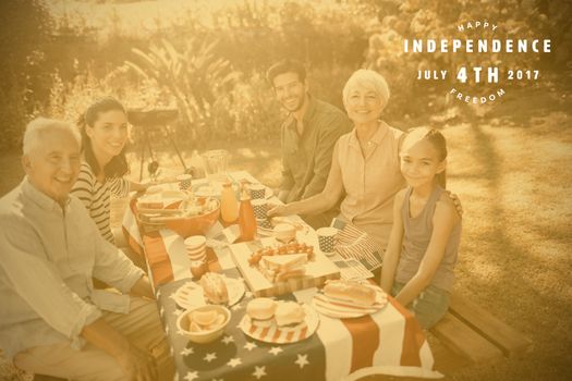 Computer graphic image of happy 4th of july text against happy family having a picnic