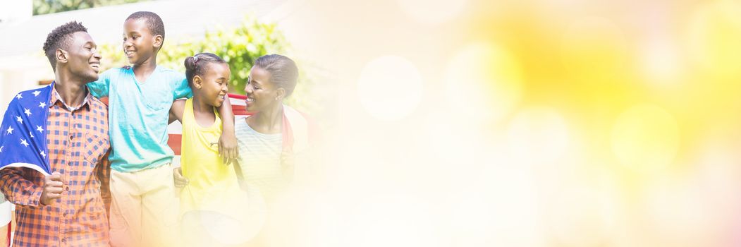 Happy family with American flag on sunny day at park