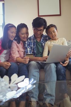 Family doing online shopping on laptop in living room at home