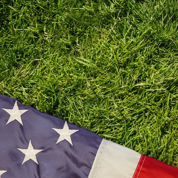 Creased US flag against grass background