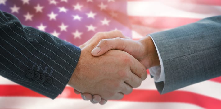 Business people shaking hands against close-up of american flag