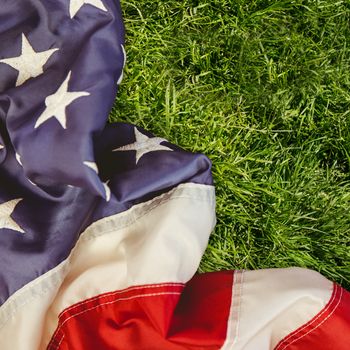 Creased US flag against grass background