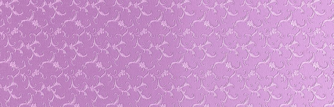 Embossed floral pattern on pink paper. Textured paper with copy space. Light pink, color of summer sunset, paper surface, closeup texture