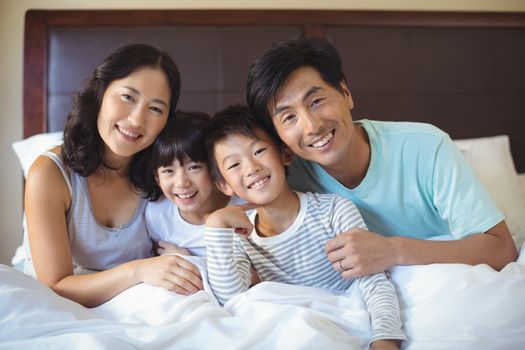 Family sitting together in bedroom at home