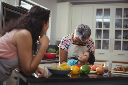 Smiling family interacting with each other in kitchen at home