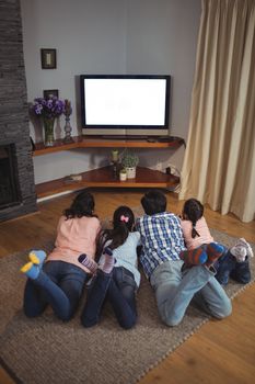 Family watching television together in living room at home