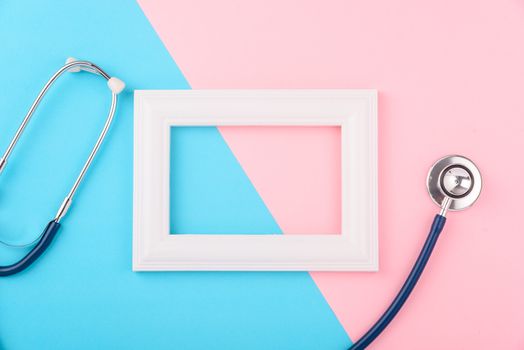 Doctor's Day concept, flat lay top view, stethoscope with photo frame on pink blue background, diagnosis of heart disease with copy space for text