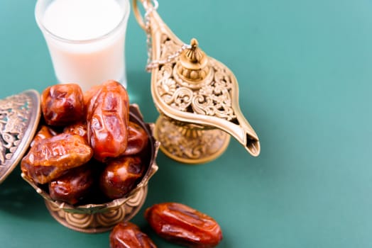 Ramadan, Dates in golden bowl, Milk, arabian Aladdin golden lamp vintage style on black green background