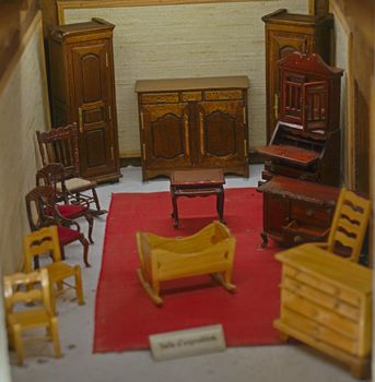 Small scale model representing room with old style wooden furniture