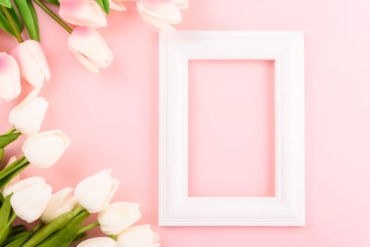 Happy Women's Day, Mother's Day concept. top view flat lay Tulip flower and photo frame on pink background, copy space for your text