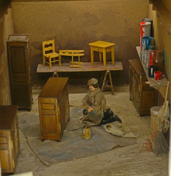 Small scale model representing old style carpenter making wooden furniture