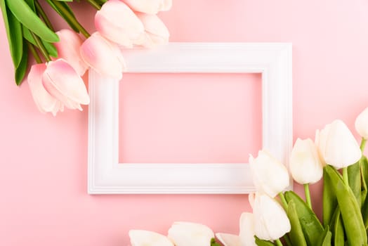 Happy Women's Day, Mother's Day concept. top view flat lay Tulip flower and photo frame on pink background, copy space for your text