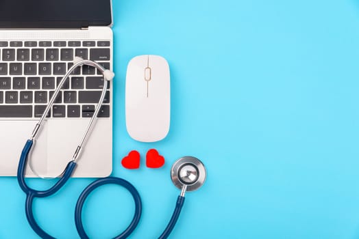 Doctor's Day concept, flat lay top view, stethoscope with laptop computer diagnosis of heart disease on blue background with copy space for text