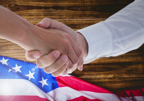 Digital composite of people shaking their hands against american flag