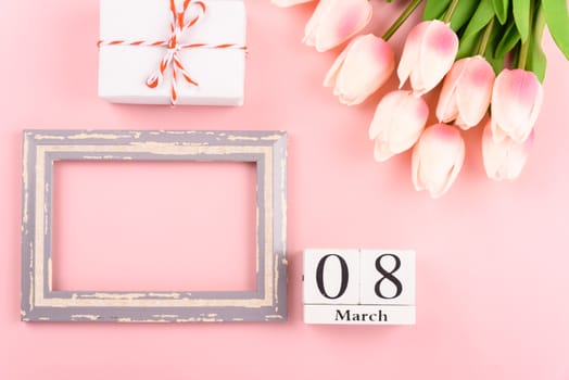 Happy Women's Day, Mother's Day concept. top view flat lay Tulip flower and photo frame on pink background, copy space for your text