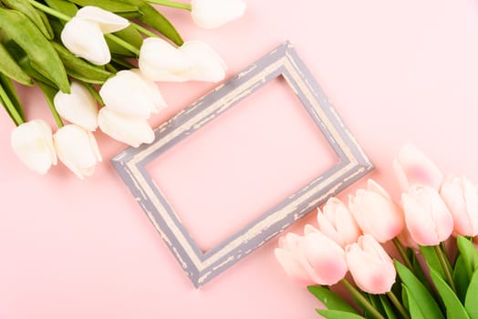 Happy Women's Day, Mother's Day concept. top view flat lay photo frame and Tulip flower on pink background, copy space for your text