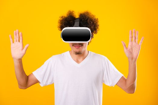 Asian handsome man with curly hair he using virtual reality headset or VR glass isolate on yellow background