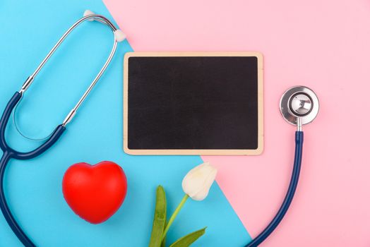 Doctor's Day concept, flat lay top view, stethoscope with black board on pink blue background, diagnosis of heart disease with copy space for text
