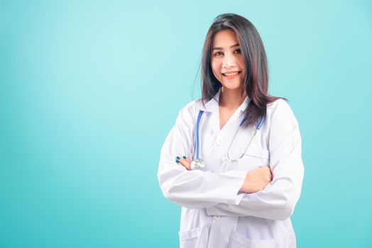 Portrait asian beautiful doctor woman smiling her standing with arms crossed on blue background, with copy space for text