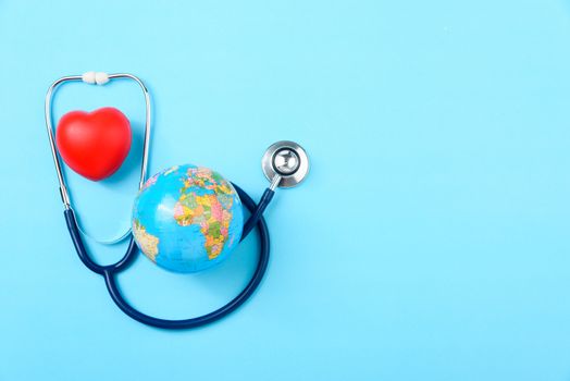 World health day concept, Stethoscope, globe and red heart on blue background with copy space. Global health care