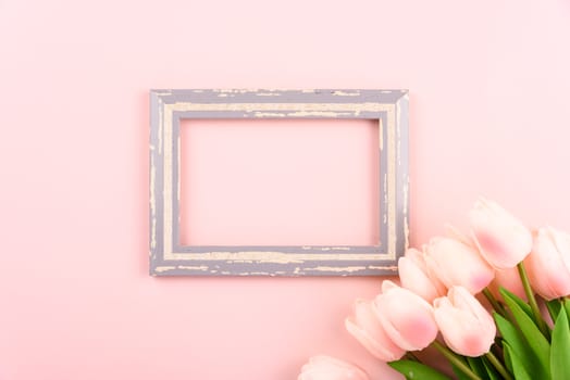 Happy Women's Day, Mother's Day concept. top view flat lay photo frame and Tulip flower on pink background, copy space for your text