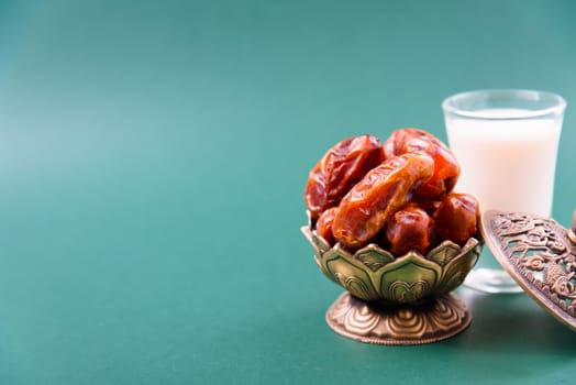 Ramadan, Dates in golden bowl, Milk, arabian Aladdin golden lamp vintage style on black green background