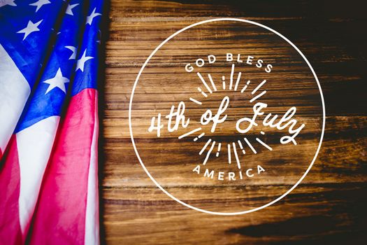 Digital composite of 4th of July design on wooden background with american flag