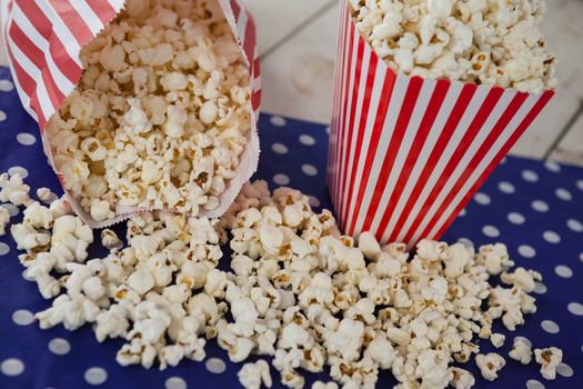 Scattered popcorn on wooden table with 4th july theme