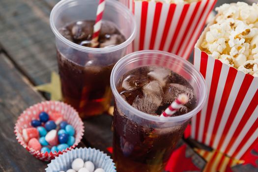 Close-up of popcorn, confectionery and drink with 4th july theme