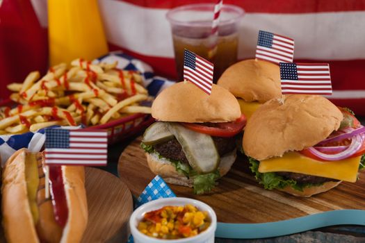 Hot dog and hamburgers decorated with 4th july theme on wooden board