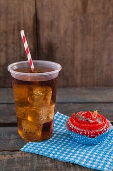 Decorated cupcake and cold drink with 4th july theme on wooden table