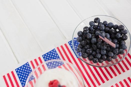 Black berries in bowl with 4th july theme on wooden table
