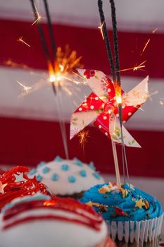 Close-up of burning sparkler on decorated cupcakes with 4th july theme