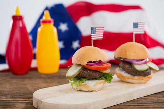 Burgers arranged on wooden board with 4th july theme