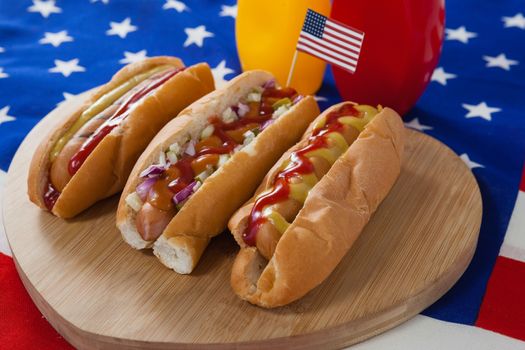 Close-up of hot dog on heart shape wooden board with 4th July theme