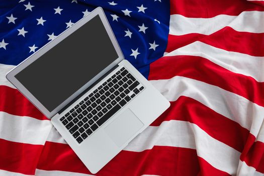 Close-up of laptop on American flag with 4th july theme