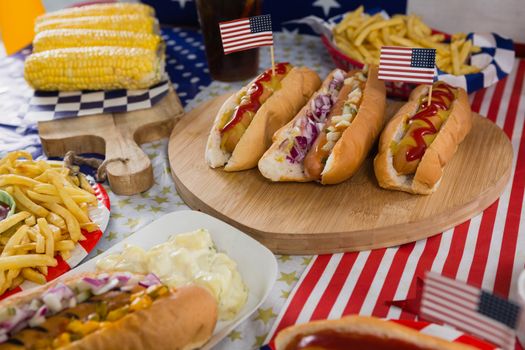 Close-up of burgers and corn cob on wooden table with 4th july theme