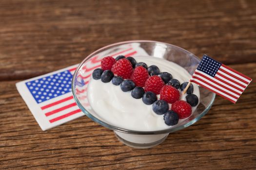 Close-up of fruit ice cream decorated with 4th july theme on wooden table