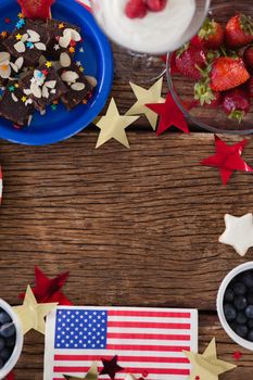 Various sweet foods and fruits arranged on wooden table with 4th July theme