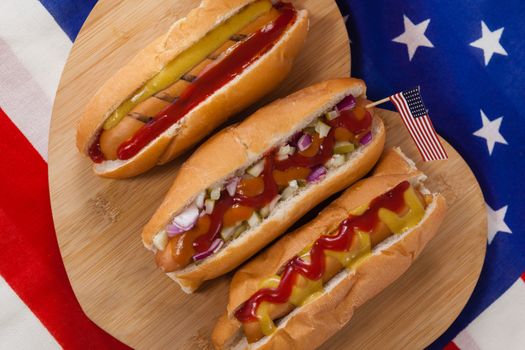 Close-up of hot dog on heart shape wooden board with 4th July theme