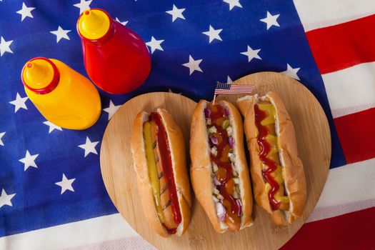 Close-up of hot dog on heart shape wooden board with 4th July theme