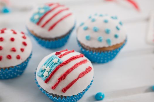Close-up of cupcakes decorated with 4th july theme on wooden table