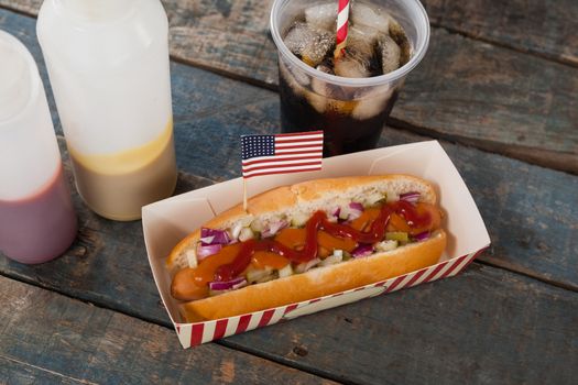Hot dog and cold drink with 4th july theme on wooden table